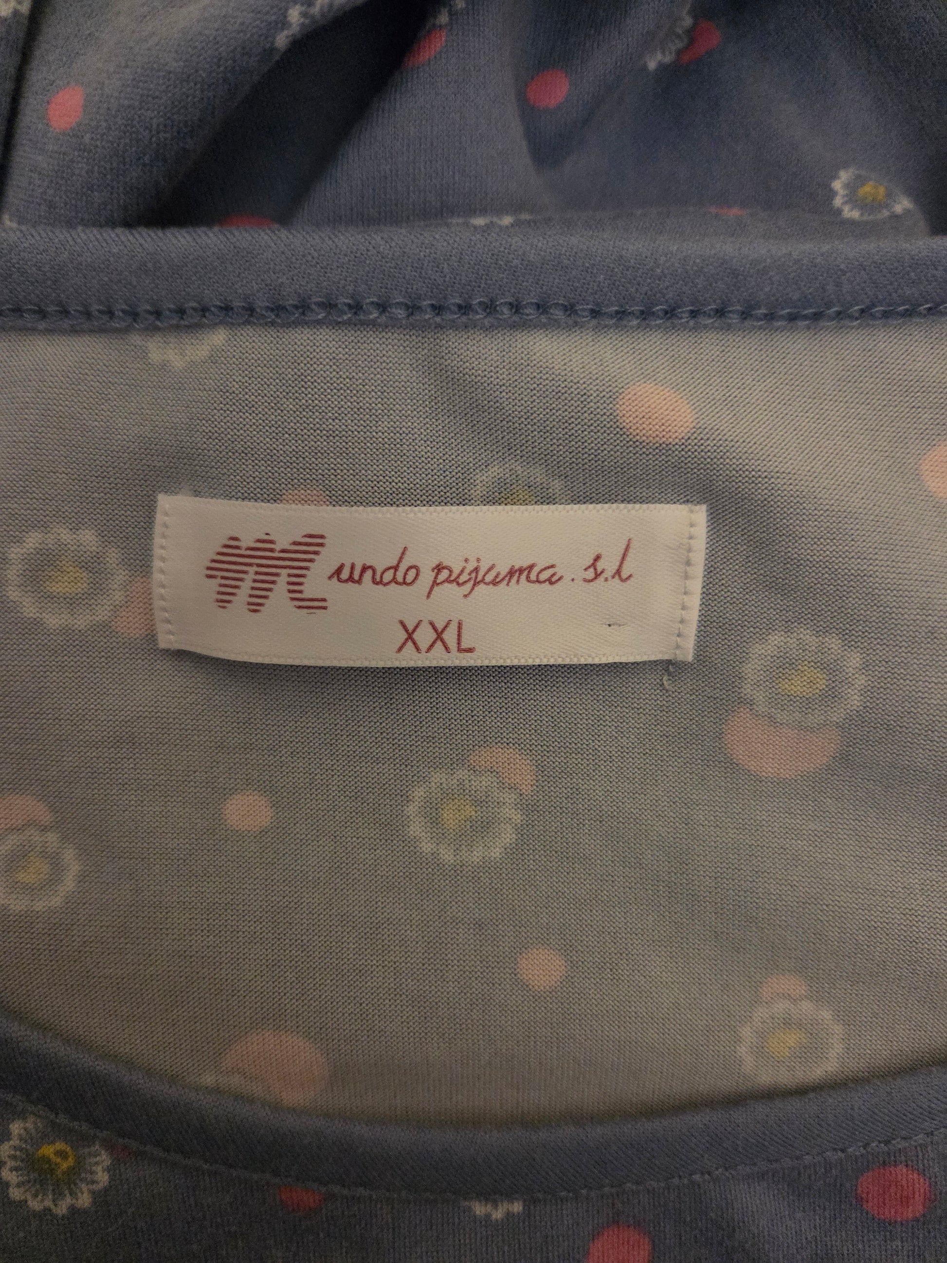 Fabric with a label on a garment, featuring a brand logo and text.