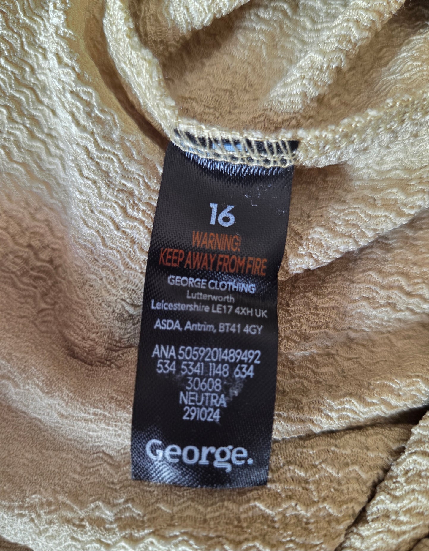 Clothing label with brand name and care instructions on a textured fabric background