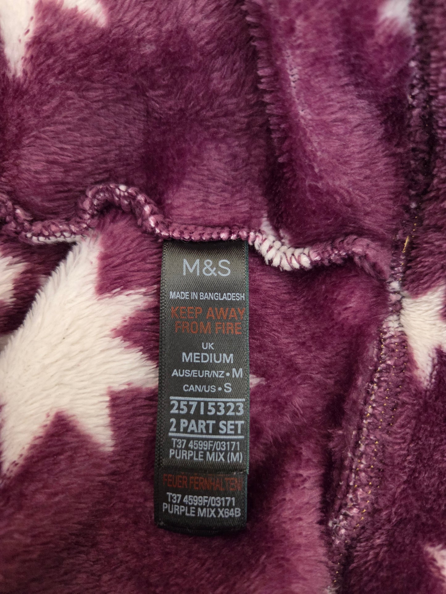 Close-up of a M&S size label on a purple fabric with white patterns
