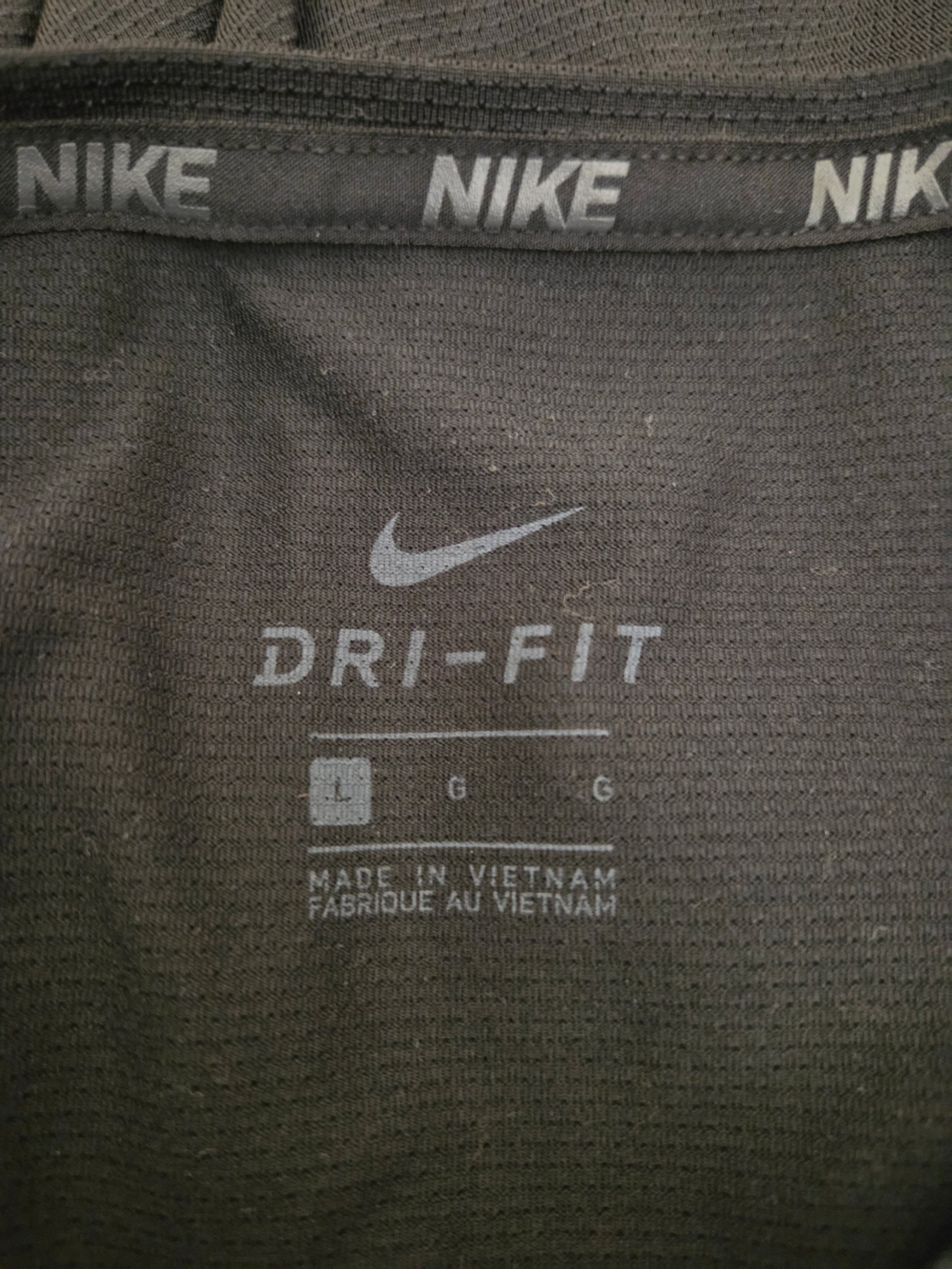 Close-up of Nike Dri-FIT label on a black athletic shirt.