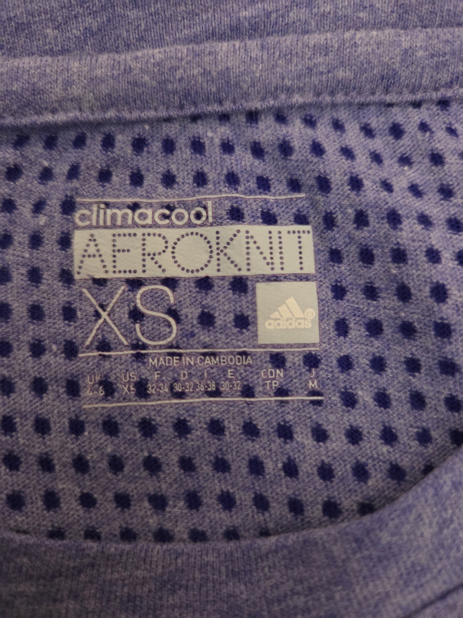 Close-up of Adidas climacool Aeroknit XS label on a textured fabric background
