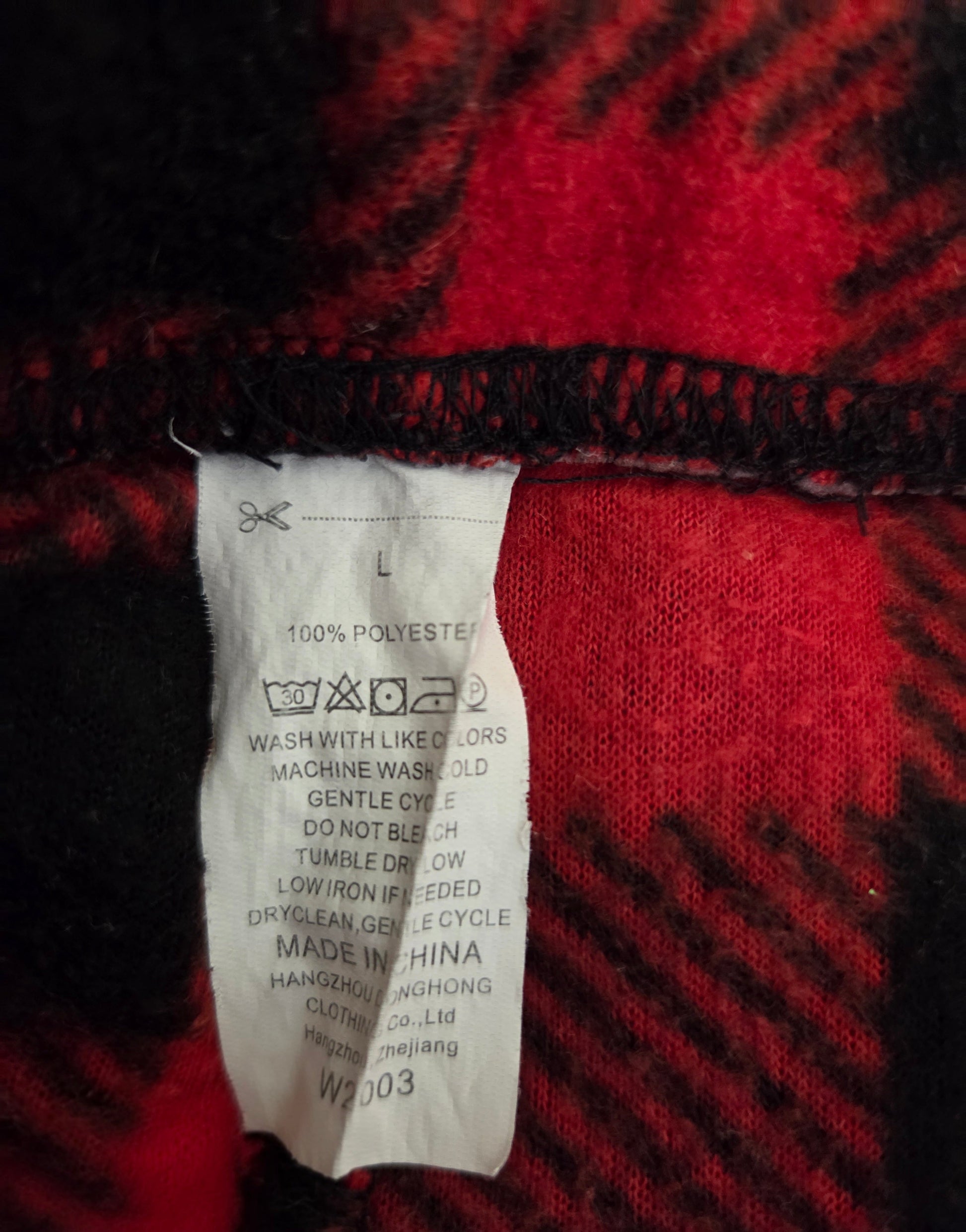Red and black check pajama bottoms with elastic waistband, size large, made of polyester, inside view with care label