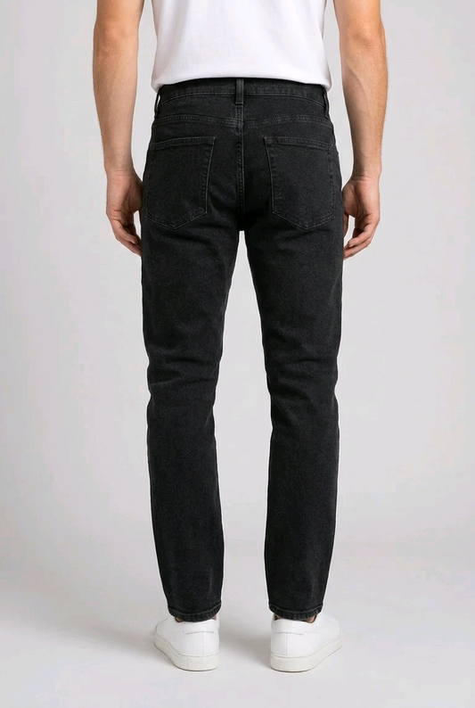 Person wearing black jeans and white shoes on a plain background