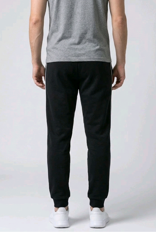 Man wearing black joggers and a grey shirt 
