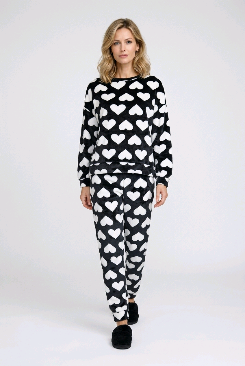 Woman wearing a black and white heart-patterned pajama set 