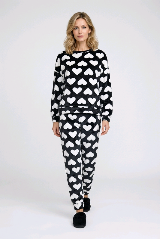 Woman wearing a black and white heart-patterned pajama set 