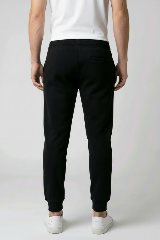 Person wearing black joggers and white trainers