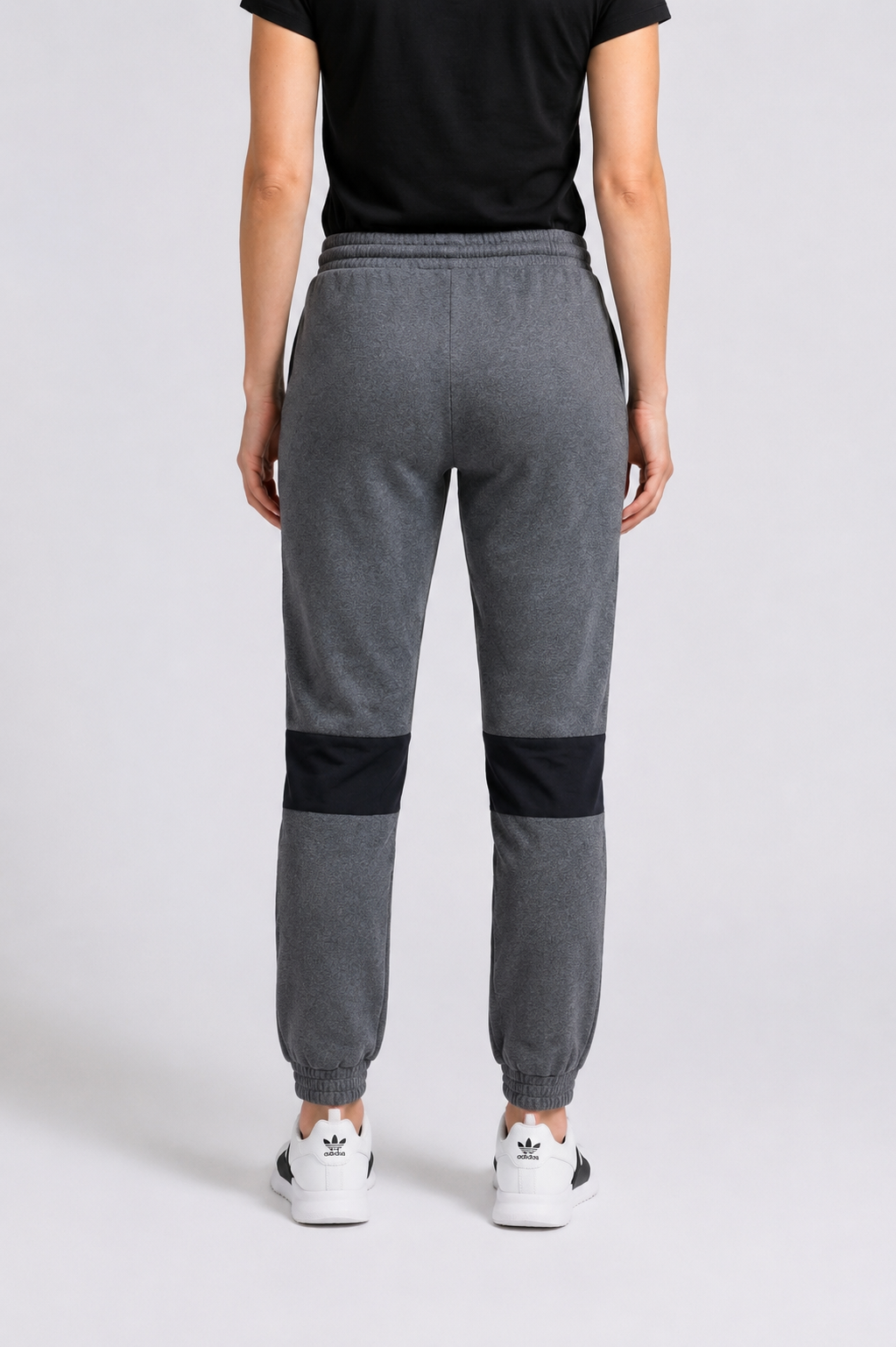 A person shown from the back wearing grey joggers