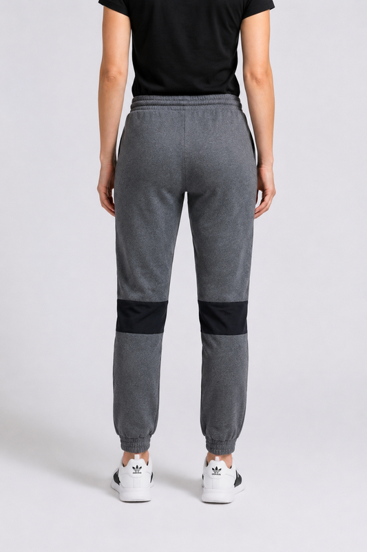 A person shown from the back wearing grey joggers