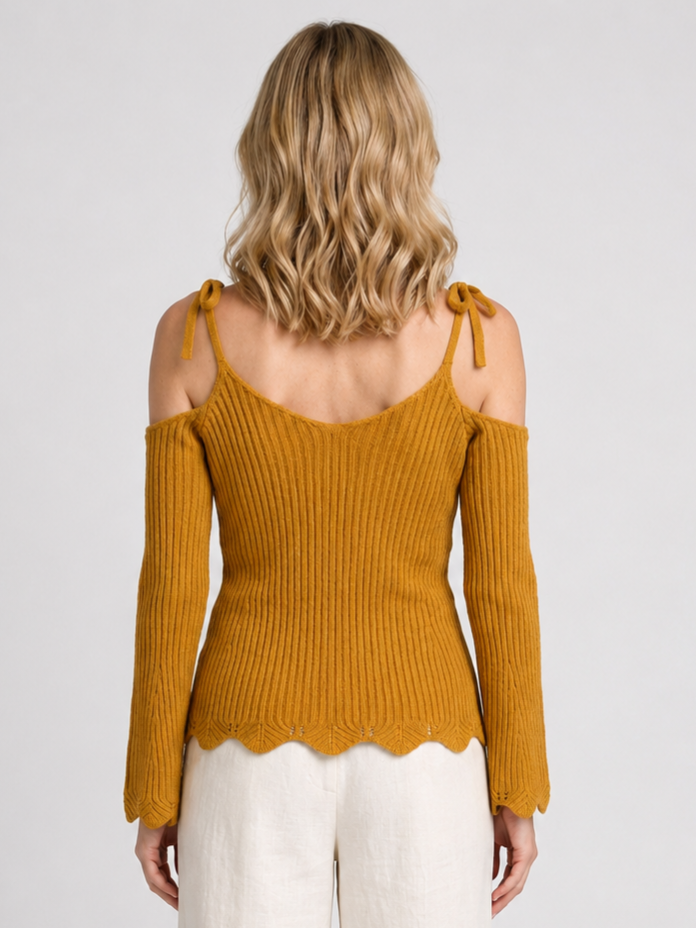 A woman viewed from the back wearing a ribbed knit cold-shoulder top in a mustard yellow color