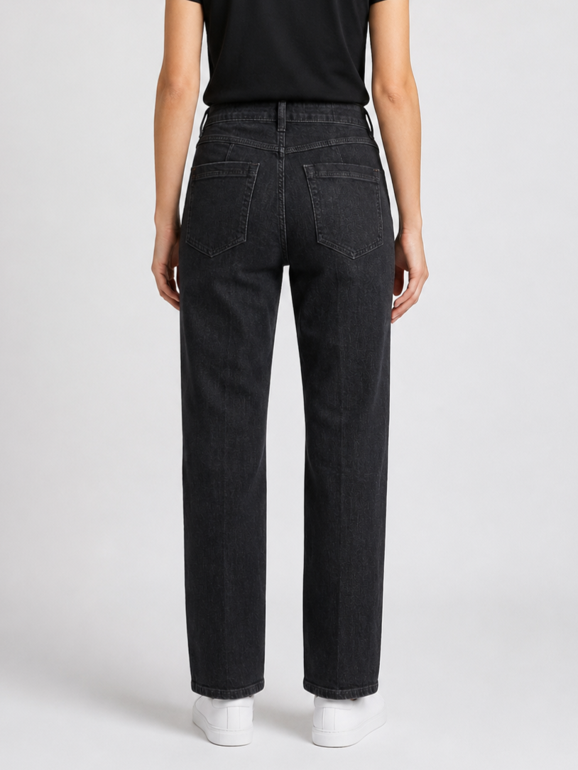 Person wearing black jeans on a plain background