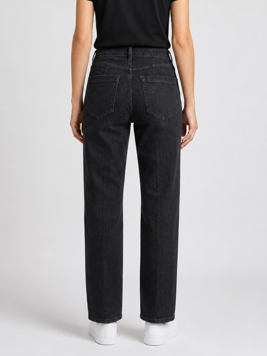 Person wearing black jeans on a plain background