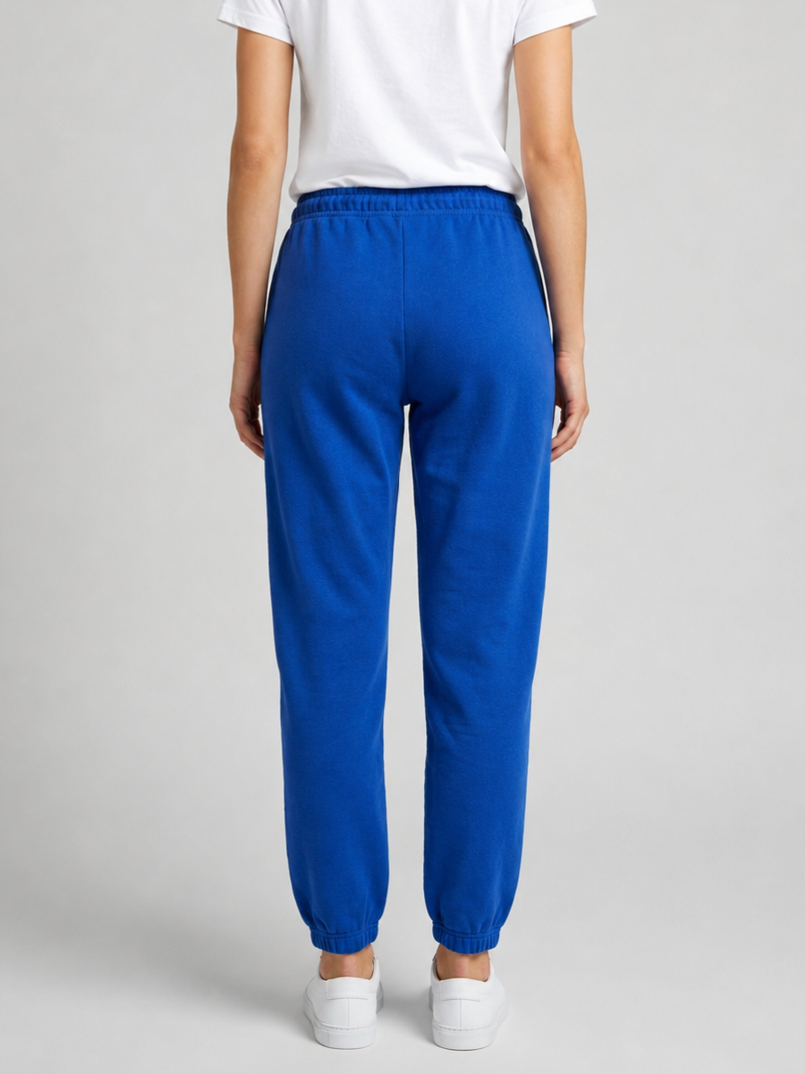 Woman wearing blue joggers and a white shirt back view