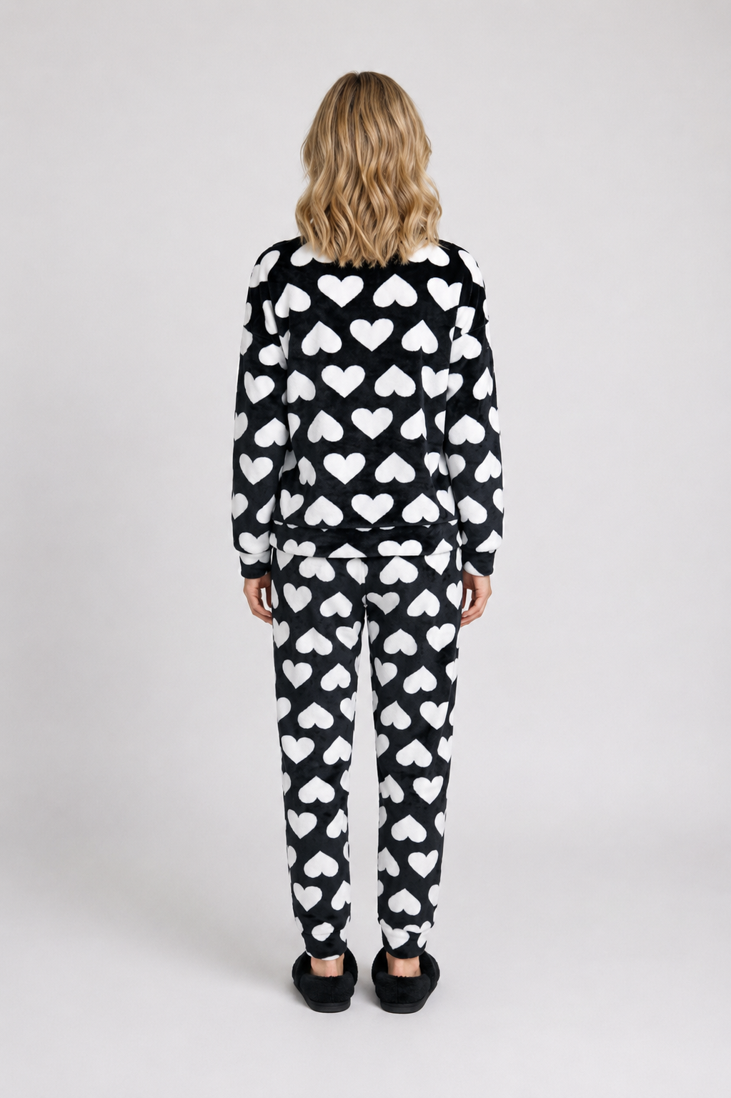 Woman wearing a black and white heart-patterned pajama 