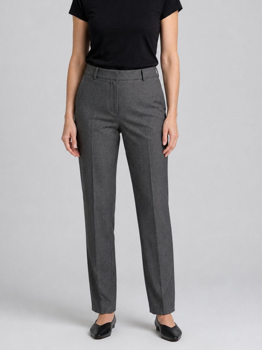 Woman wearing grey trousers and a black top 