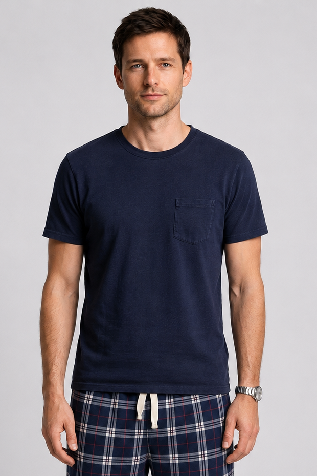 Man wearing navy t-shirt and plaid pyjama pants