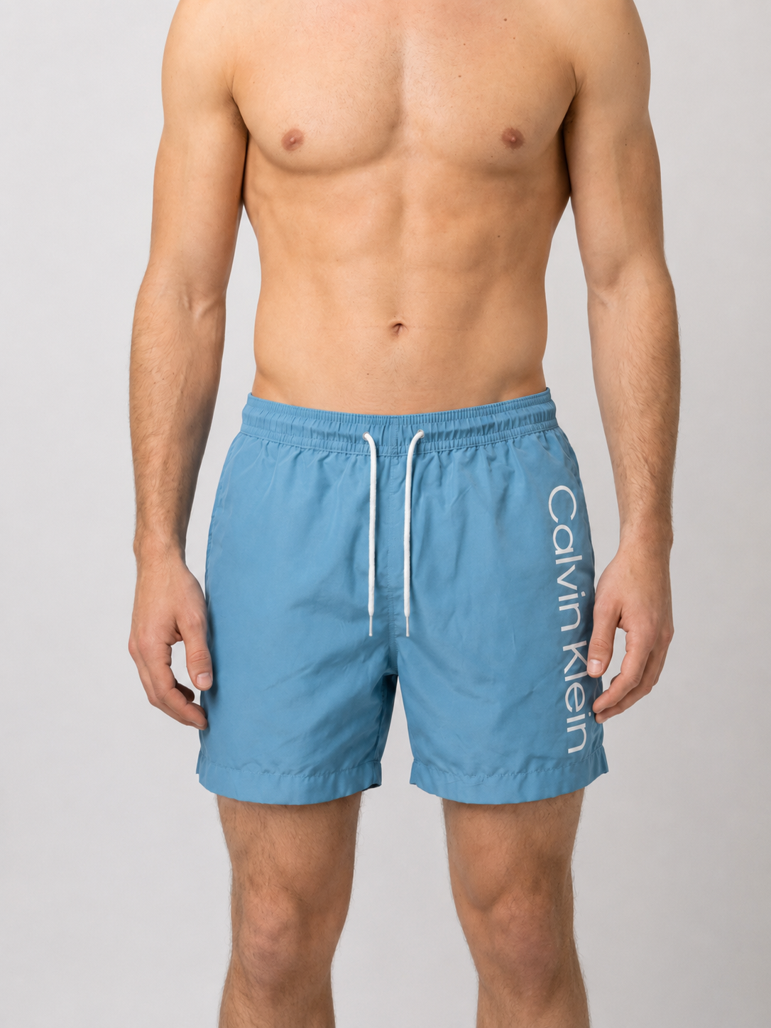 Man wearing blue Calvin Klein swim shorts