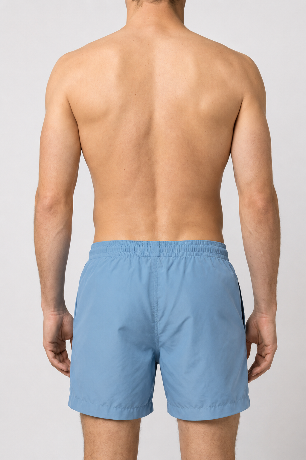 Man wearing light blue swim shorts back view