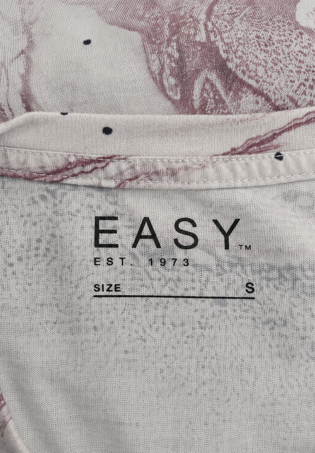 Close-up of a brand label on a textured fabric background with 'EASY' branding.