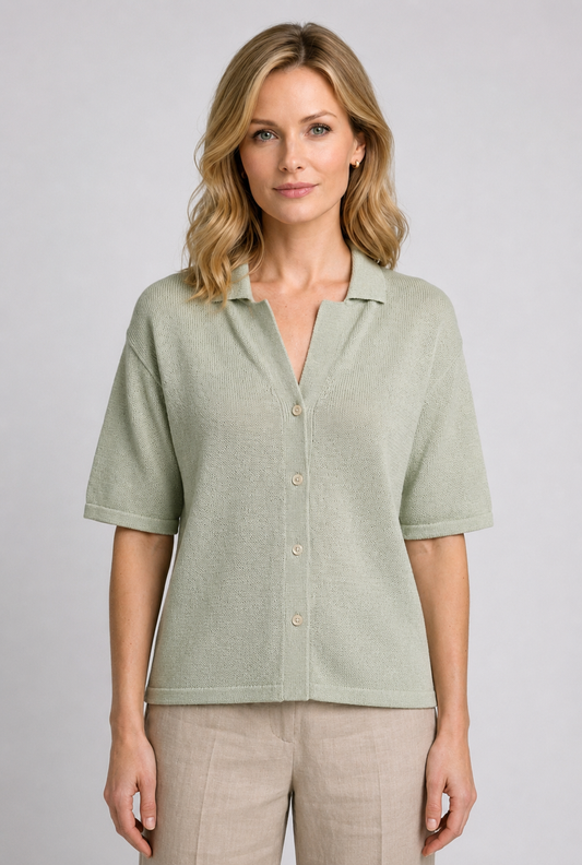 Woman wearing a light green button-up knit top and beige trousers