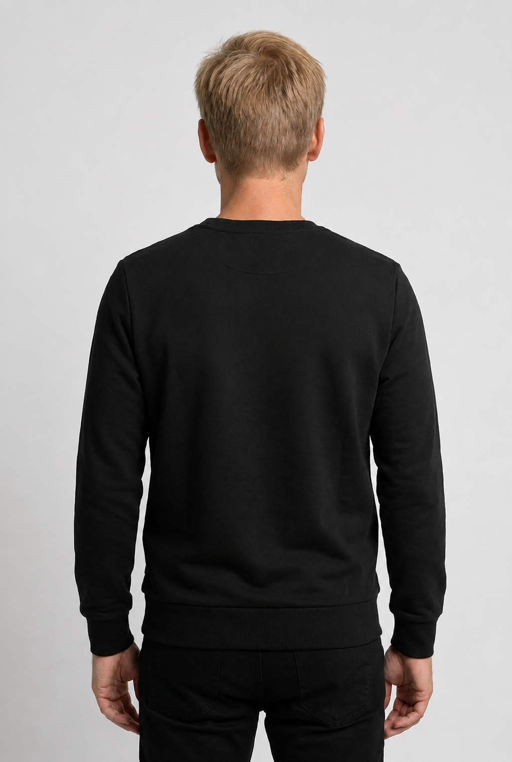 Person wearing a black sweatshirt on a light gray background