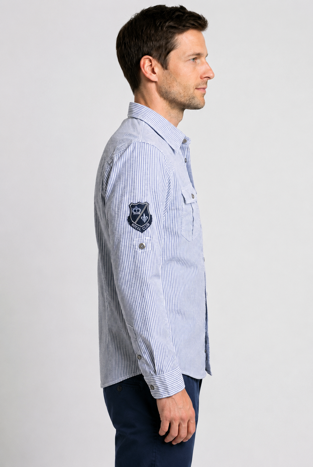 Man wearing a blue striped shirt with a logo 