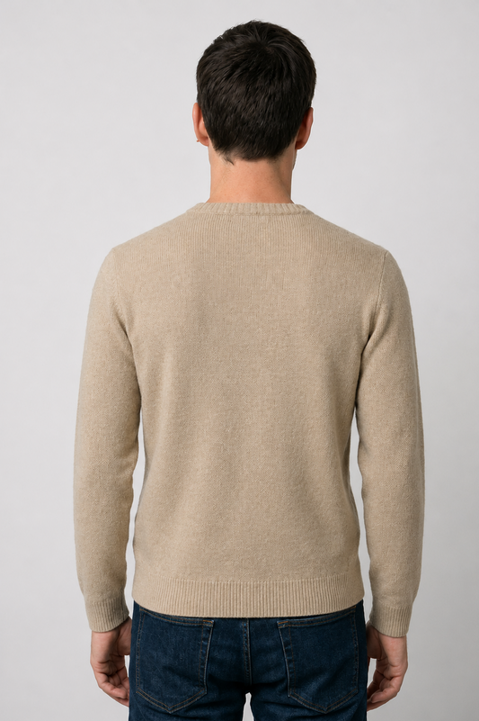Man wearing a beige sweater and dark jeans