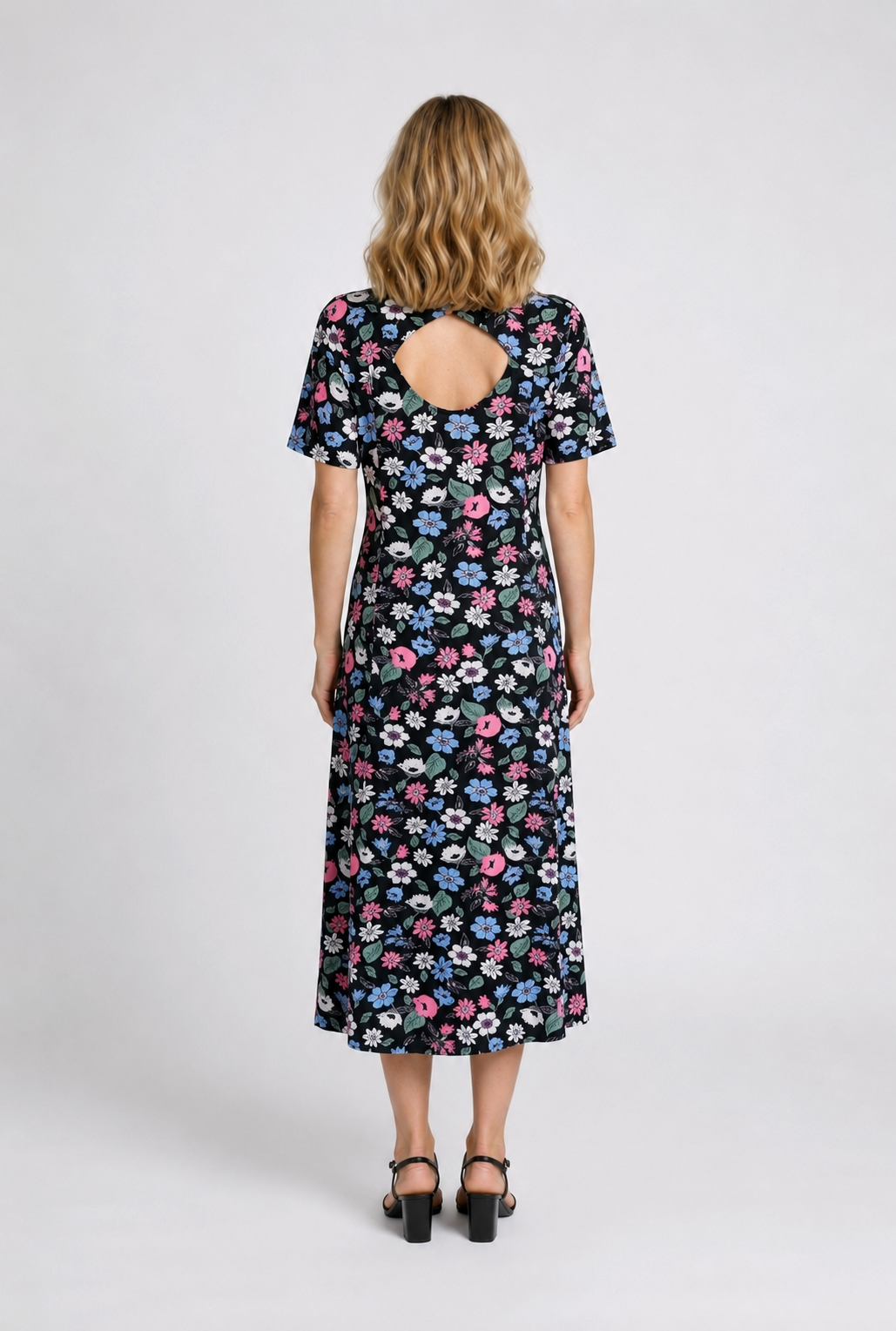 Woman wearing a floral dress with a cut-out back 