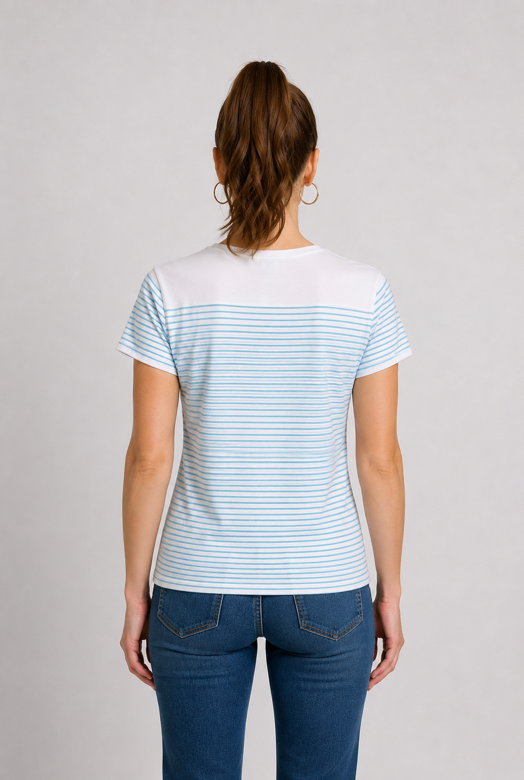 Woman wearing a white t-shirt with blue stripes and blue jeans 