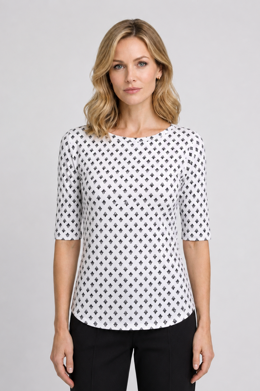 Woman wearing a white top with black pattern and black trousers