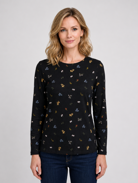 Woman wearing a black long-sleeve top with small colorful patterns 
