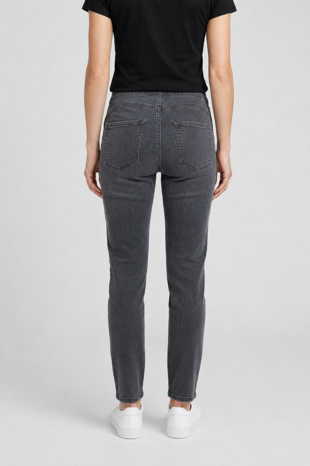 Person wearing gray jeans and a black t-shirt on a white background