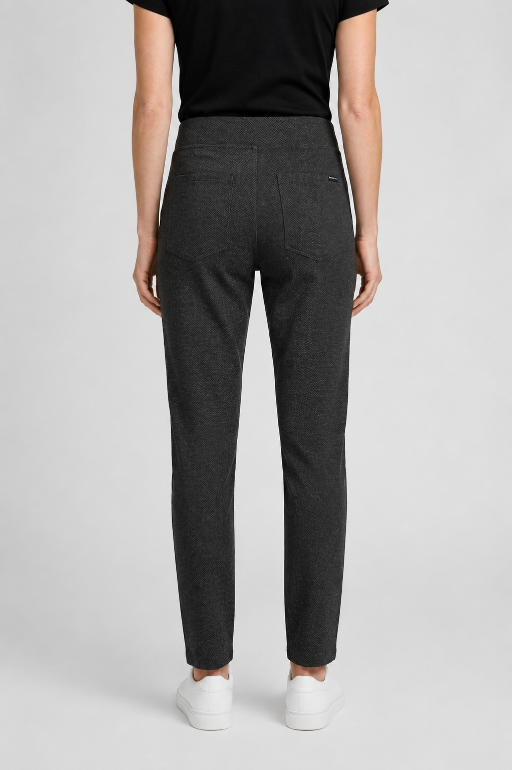 Person wearing dark gray pants on a light gray background