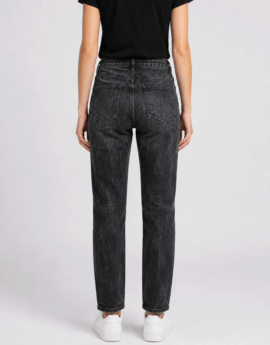 Person wearing black jeans on a white background
