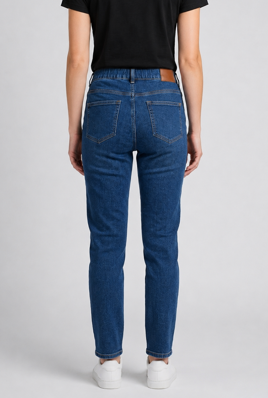 woman wearing blue jeans and a black t-shirt on a plain background