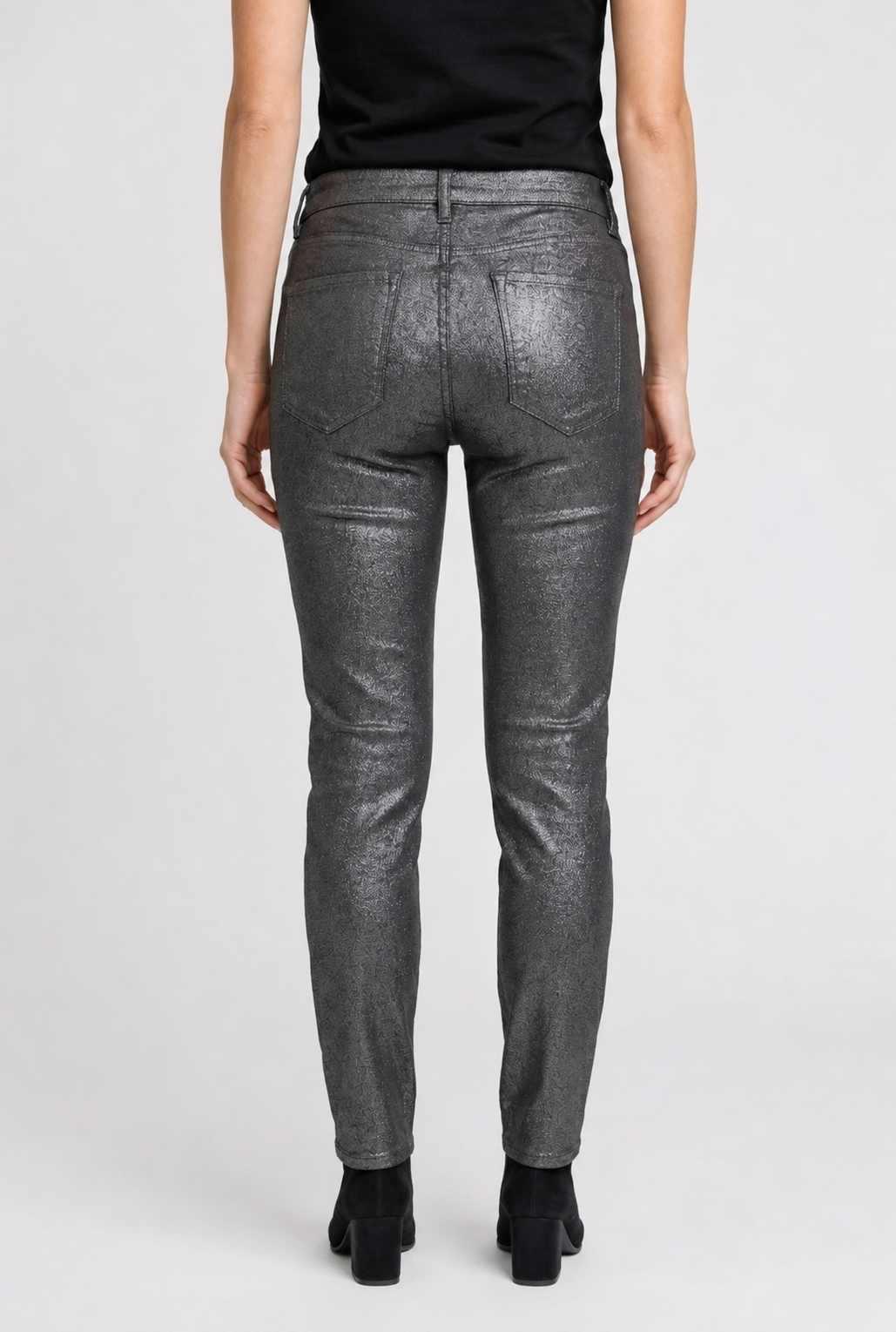 Person wearing gray metallic pants on a white background