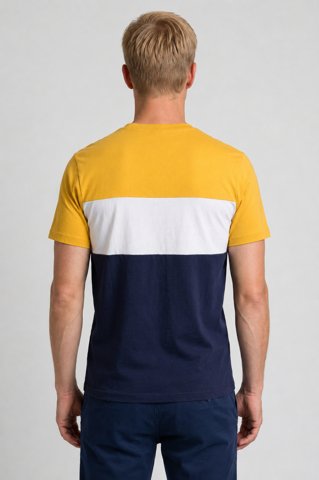 Man wearing a color-blocked t-shirt with yellow, white, and navy sections 
