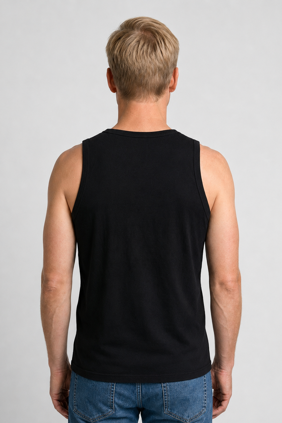 Man wearing a black tank top and blue jeans 