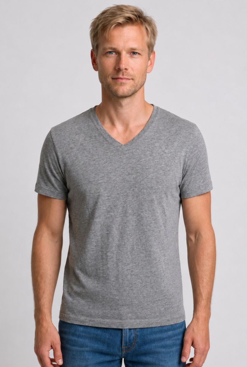 Man wearing a gray V-neck t-shirt and blue jeans 