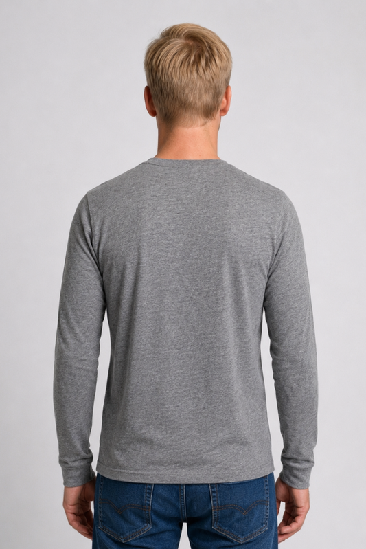 Man wearing a gray long-sleeve shirt and blue jeans