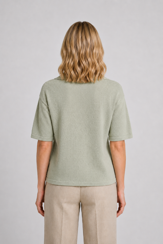 Woman wearing a light green knit top and beige trousers 