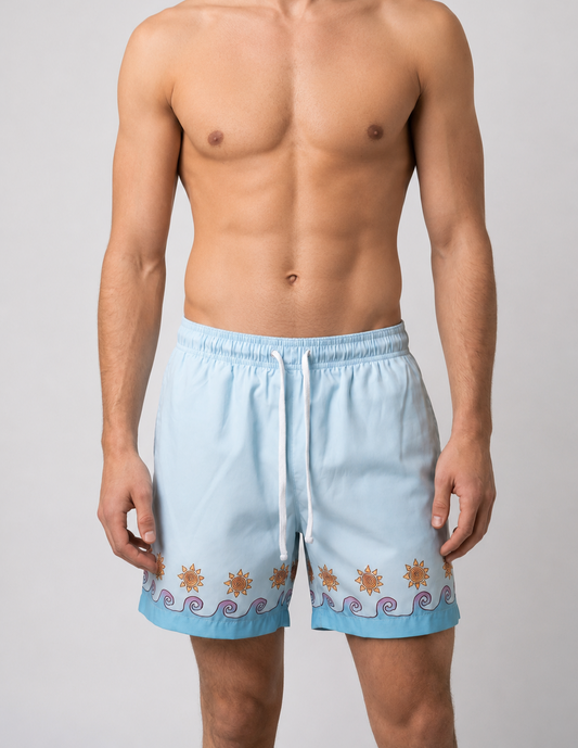 Man wearing light blue swim shorts with wave and sun designs 