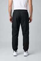 Man wearing black Nike tracksuit bottoms size L back view