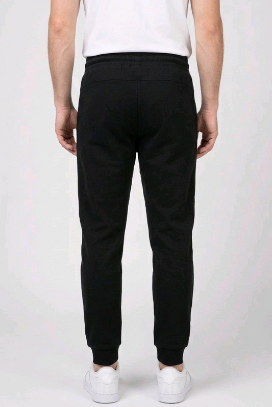 Person wearing black Reebok Delta joggers and white trainers