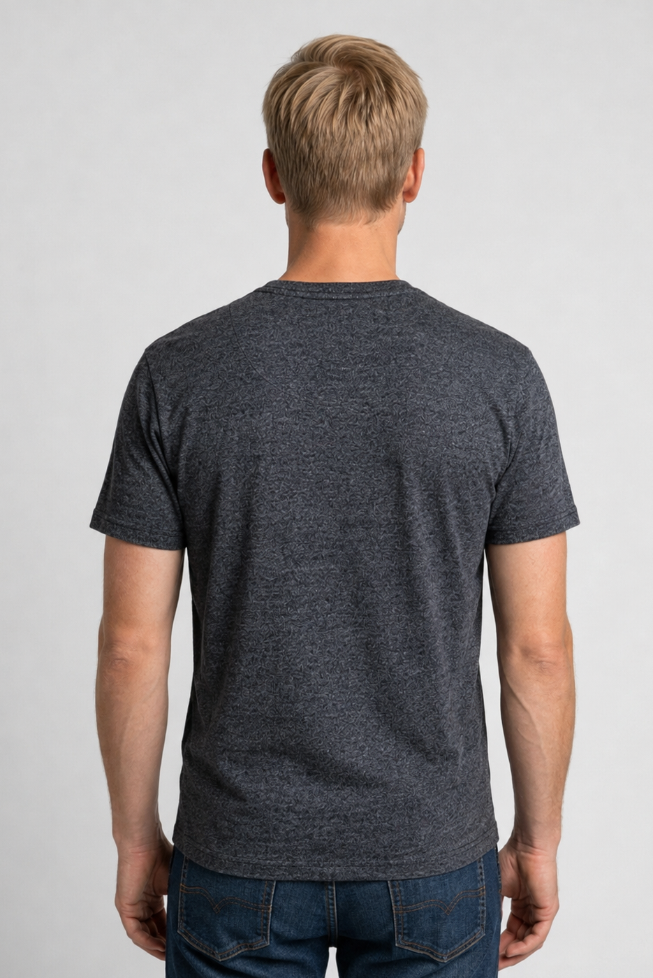 Man wearing a dark gray t-shirt and jeans 