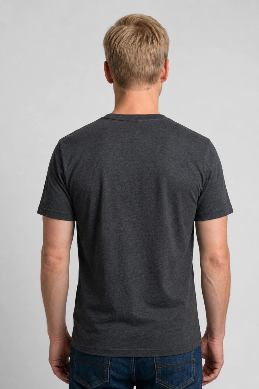 Man wearing a dark gray t-shirt and blue jeans