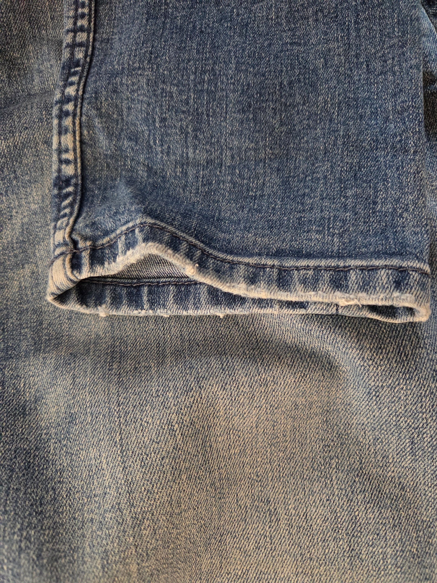 Close-up of blue denim fabric with a rolled hem