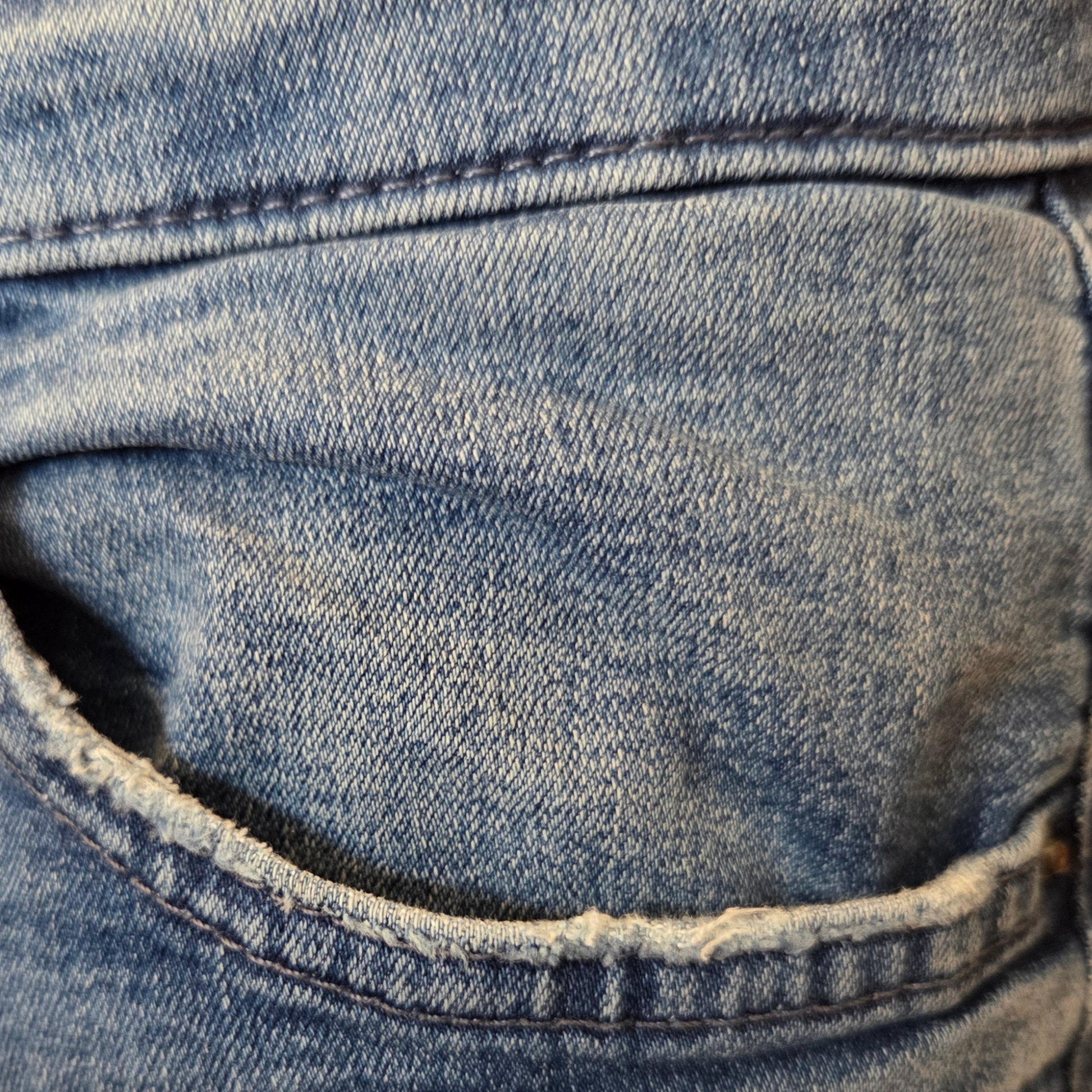 Close-up of blue denim fabric with a pocket