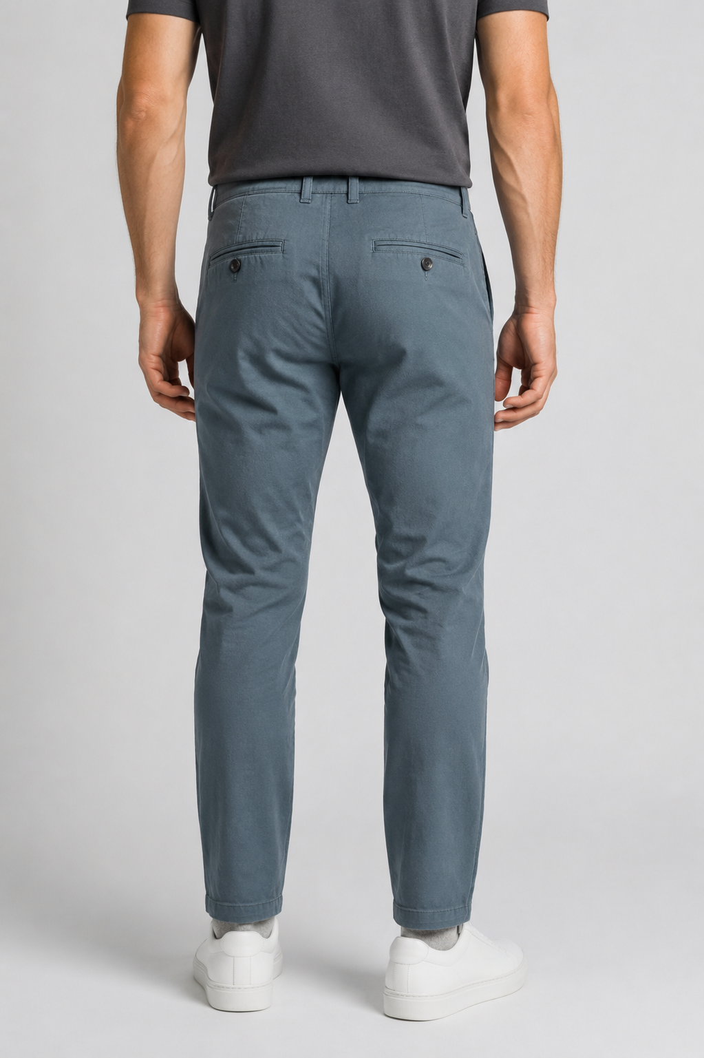 A man viewed from the back wearing teal slim-fit chinos