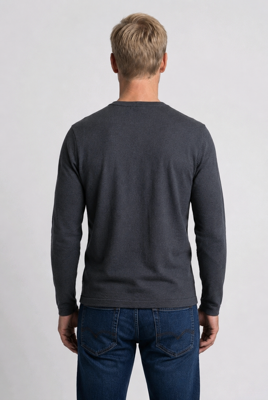 Man wearing a dark gray long-sleeve shirt and blue jeans 